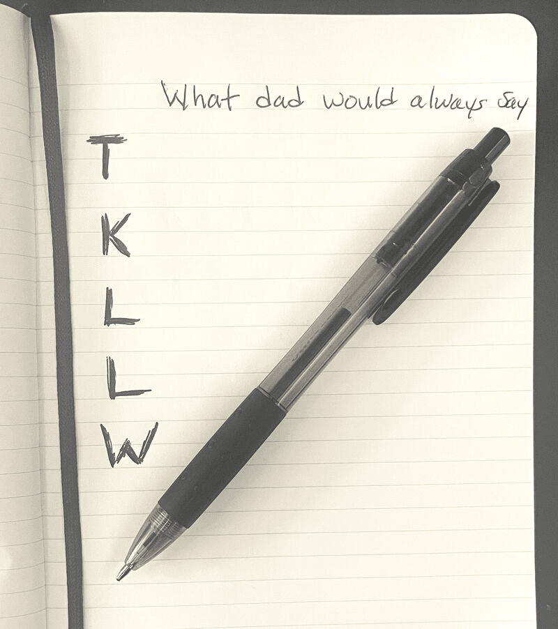 A lined notebook page with a pen resting on it, headed “What dad would always say” and the letters T, K, L, L, W written vertically down the left margin.